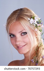 Portrait of a beautiful blonde girl with flowers in her hair