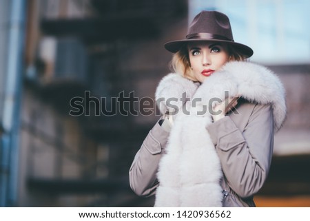 A portrait of a beautiful blonde lady walking in the street. Beauty, urban fashion, style.