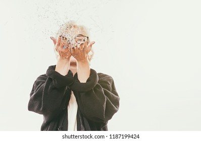 Portrait Of Beautiful Blonde Woman Blowing Confetti And Glitters In The Air, Party New Year Eve Celebration On White Background. Party Time Concept