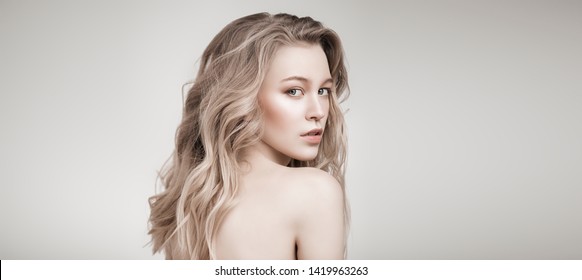 Portrait of a beautiful blonde woman with natural make-up. Beauty, haircare, cosmetics concept. Healthcare. White background.