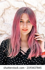 Portrait beautiful blue  eyed woman and pink hair looking into the camera against light marble wall  Hair dyeing  coloring  Hair care  hairdressing  trichology