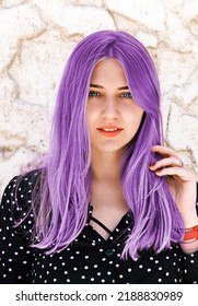 Portrait beautiful blue  eyed woman and purple hair looking into the camera against light marble wall  Hair dyeing  coloring  Hair care  hairdressing  trichology