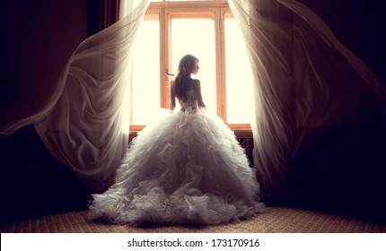 Portrait of the beautiful bride against a window indoors