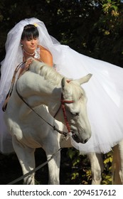 Portrait of beautiful bride with white horse 