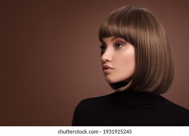 Portrait of a beautiful brown-haired woman with a short haircut on a brown background - Shutterstock ID 1931925245