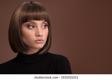 Portrait einer schönen braunhaarigen Frau mit einem kurzen Haarschnitt auf braunem Hintergrund