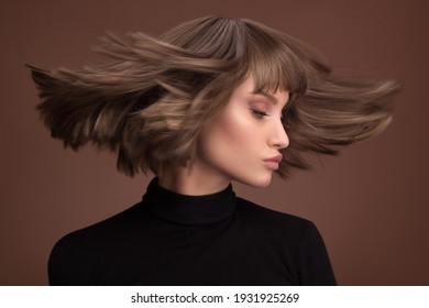 Portrait d'une belle femme aux cheveux bruns avec une courte coupe de cheveux sur fond marron