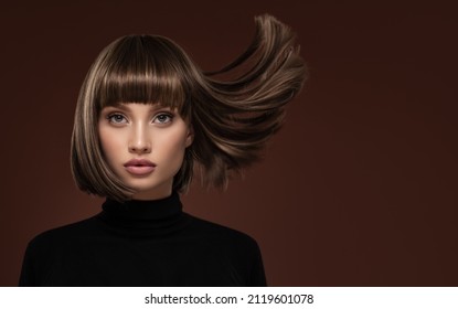 Portrait d'une belle femme aux cheveux bruns avec une courte coupe de cheveux sur fond marron