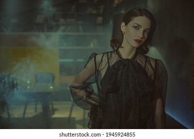 Portrait Of A Beautiful Brunette Girl  With Evening Make-up And In Elegant Black Blouse Posing At Smoky Club. Beauty, Fashion Concept. Evening Make-up And Hairstyle.