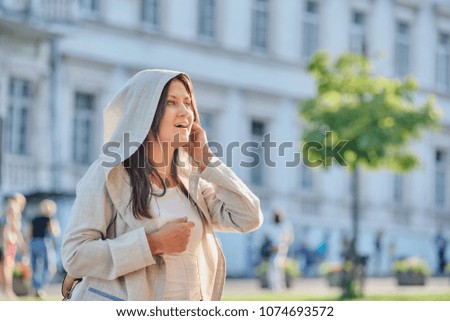 Portrait of beautiful brunette woman listening music in the city