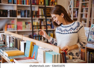 Portrait of a beautiful brunette woman looking for a book in store