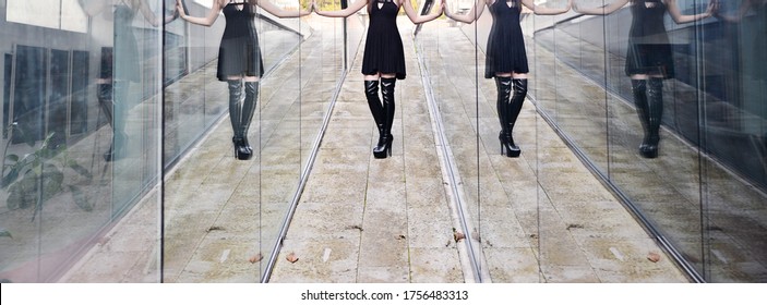 Portrait Of A Beautiful Brunette Woman. The Model Is Wearing A Short Black Skirt And Knee High Leather Boots. High Heels