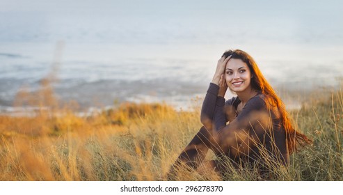 Portrait Of The Beautiful Brunette Woman At The Windy Autumn Day Relaxing On Coast Feeling Good