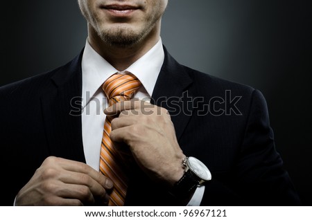 portrait  the  beautiful  businessman  in black costume tie one's necktie