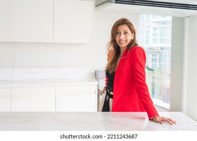 Portrait Of Beautiful Businesswoman In Office Wearing Red Suit Jacket And Smiling