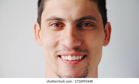 Portrait Schöner kaukasischer junger Mann lächelt auf die Kamera. Glückliche Männer Emotionen auf einem weißen Hintergrund. 