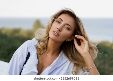 Portrait of beautiful  charming blond woman with perfect skin and wavy hairs  posing outdoor during vacation in  Europe. 