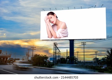 Retrato de una encantadora joven mujer asiática posando en la cara y sentada con anuncios de mesa blanca en una valla publicitaria en blanco para afiches publicitarios al aire libre o carteles en blanco para publicidad.