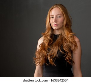 Portrait of beautiful cheerful redhead girl smiling laughing looking at camera over black background.