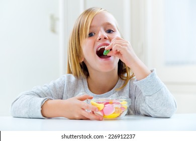 Portrait Of Beautiful Child Eating Sweets At Home. 