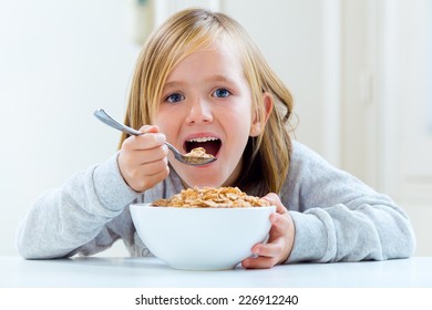 Portrait of beautiful child having breakfast at home.