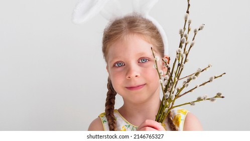 Portrait Of A Beautiful Child With Willow. Palm Sunday Holiday. Happy Easter. Girl With Bunny Ears. Blue-eyed Child Congratulates On Easter. Banner.