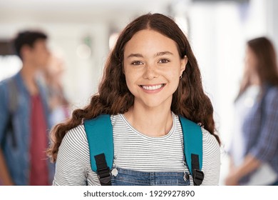 Portrait of beautiful college student standing in hallway school while looking at camera. Intelligent university girl with backpack smiling. Proud and satisfied teen in high school corridor standing. - Powered by Shutterstock