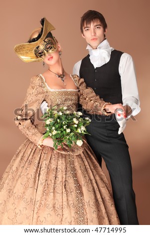 Portrait of a beautiful couple in medieval era costumes. Shot in a studio.