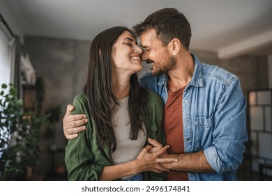 Portrait of beautiful couple stand, smile and hug at home - Powered by Shutterstock