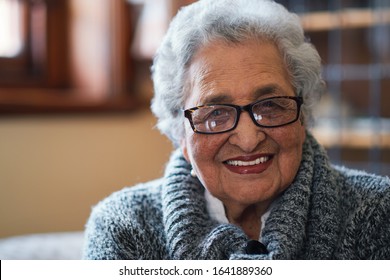 Portrait beautiful elderly woman smiling sitting on sofa at home enjoying retirement