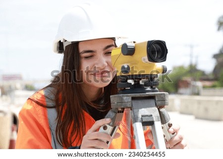 Portrait of a beautiful engineer woman at the construction site with the survey instrument 