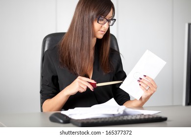 Portrait Of A Beautiful Executive Woman Secretary At Work While Open A Letter