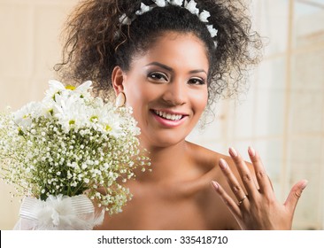 Portrait Of Beautiful Exotic African American Bride Wearing White Dress And Holding Flower Bouquet Showing Wedding Ring