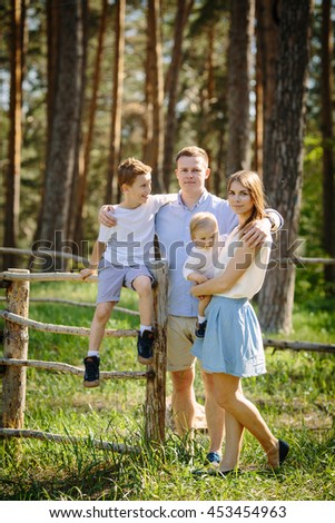 Portrait of beautiful family of four people mother father son daughter park near forest