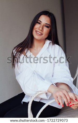 Portrait of a beautiful fashionable oriental brunette woman in a white shirt
