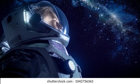 Portrait of the Beautiful Female Astronaut on the Alien Planet Looking at the Milky Way Galaxy. Space Travel, Exploration and Solar System Colonization Concept.