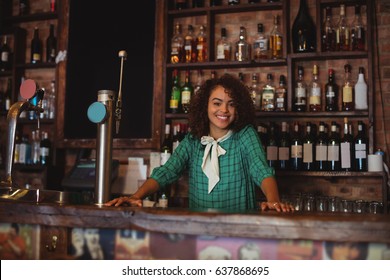 Portrait of beautiful female bar tender standing at bar counter - Powered by Shutterstock