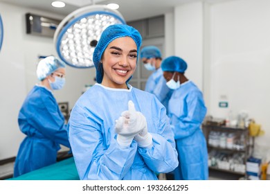 Portrait of beautiful female doctor surgeon putting on medical gloves standing in operation room. Surgeon at modern operating room