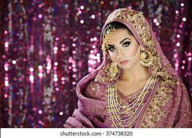 Portrait Of A Beautiful Female Fashion Model In Ethnic Asian Indian Bridal Costume With Heavy Jewellery And Makeup