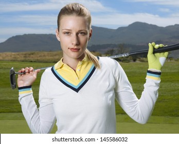 Portrait Of Beautiful Female Golfer With Club On Golf Course