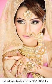 Portrait Of A Beautiful Female Model In Traditional Indian Bridal Costume With Makeup And Jewellery