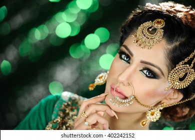 Portrait of a beautiful female model in traditional ethnic asian indian bridal costume with heavy makeup and jewellery