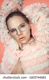 Portrait Of A Beautiful Female Model With Wet Hair, Wearing A Striped Pink Fur Coat And Glossy Eyeglasses