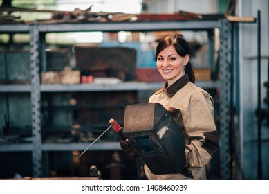 Portrait Of A Beautiful Female Welder At Work, Smiling At Camera.