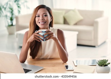 Portrait of beautiful Filipino girl holding cup of hot chocolate
