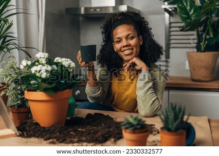 Portrait of a beautiful florist woman sitting in front of her working surface and drinking coffee.