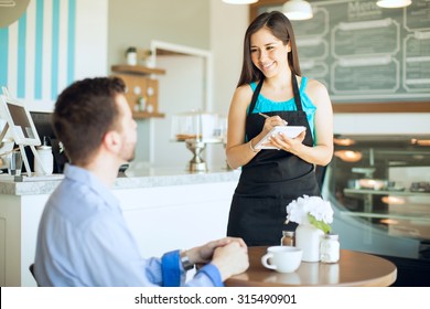 Portrait of a beautiful friendly waitress taking an order from a customer and writing it down on a notepad