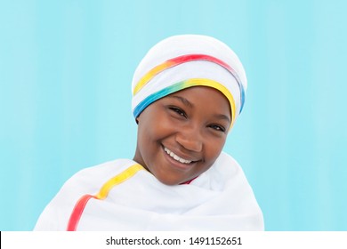 Portrait of a beautiful girl (12 years old) wearing a celebration clothing, isolated, blue background