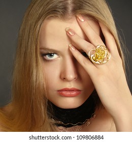 Portrait of the beautiful girl in the big Golden Ring a hand closing an eye