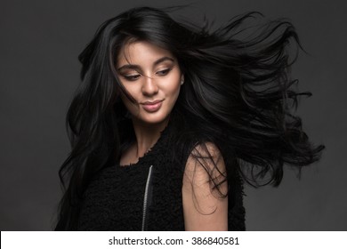 Portrait of a beautiful girl with black hair on a dark background